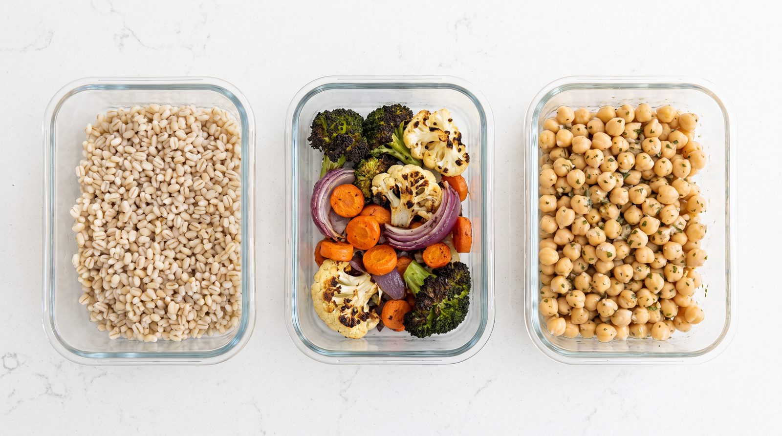 Meal prep components in separate containers: cooked barley, roasted vegetables and seasoned chickpeas